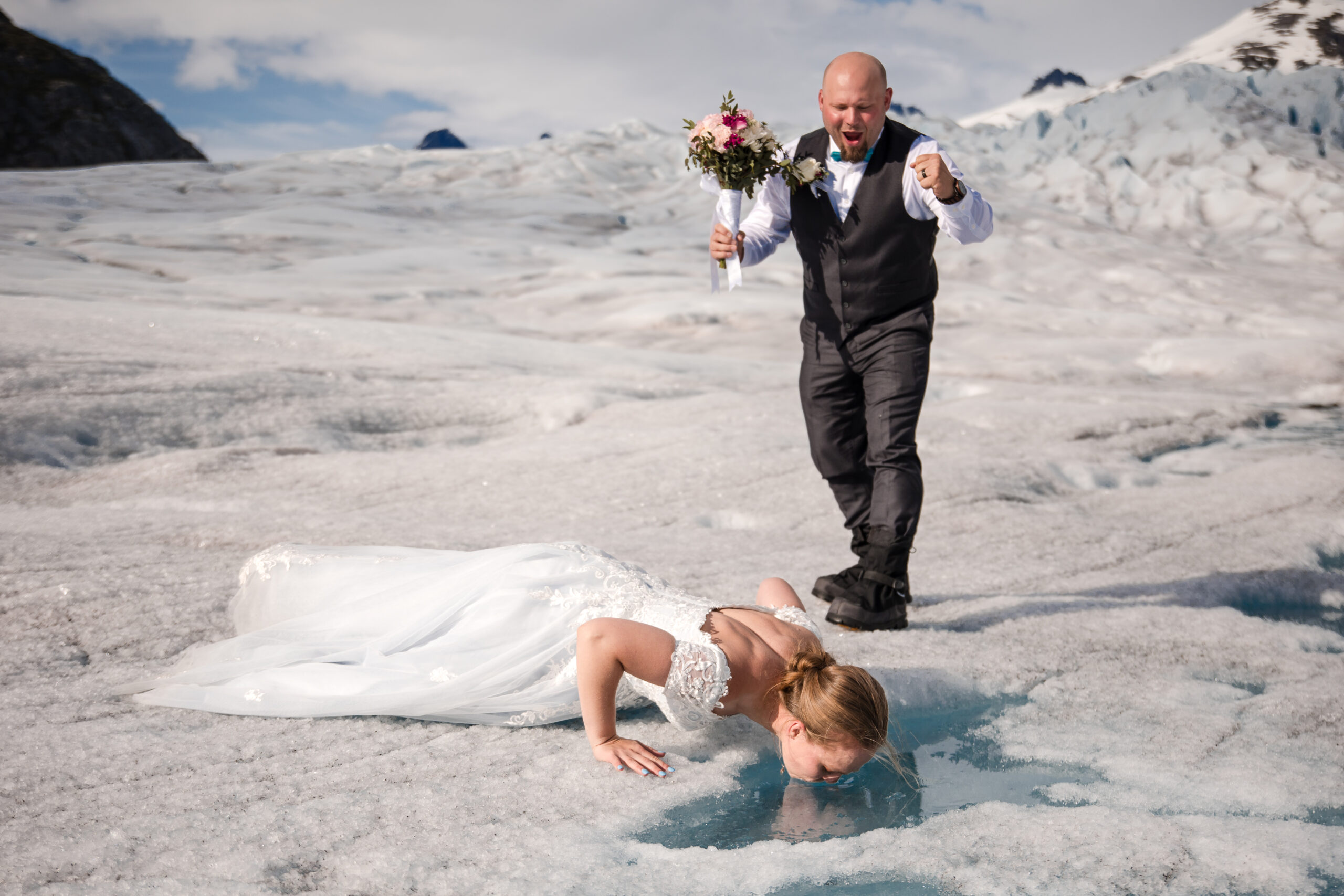 Bride drinks water from Alaskan Glacier during their helicopter elopement on Herbert Glacier